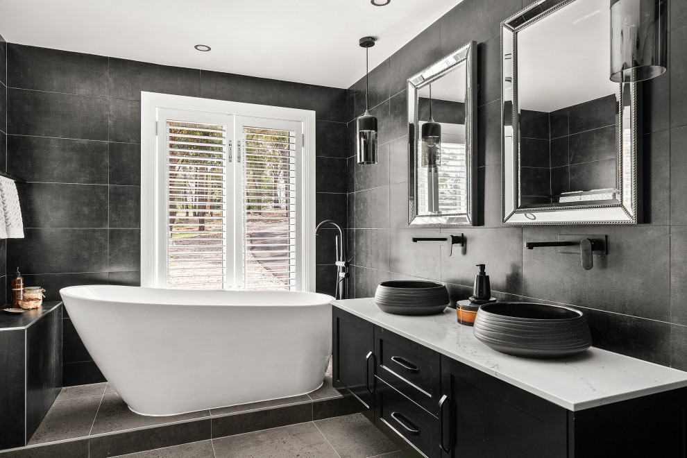 Design ideas for a large contemporary master bathroom in Sydney with black cabinets, a freestanding tub, gray tile, grey walls, ceramic floors, granite benchtops, white benchtops, a floating vanity, shaker cabinets, a vessel sink, grey floor and a double vanity.