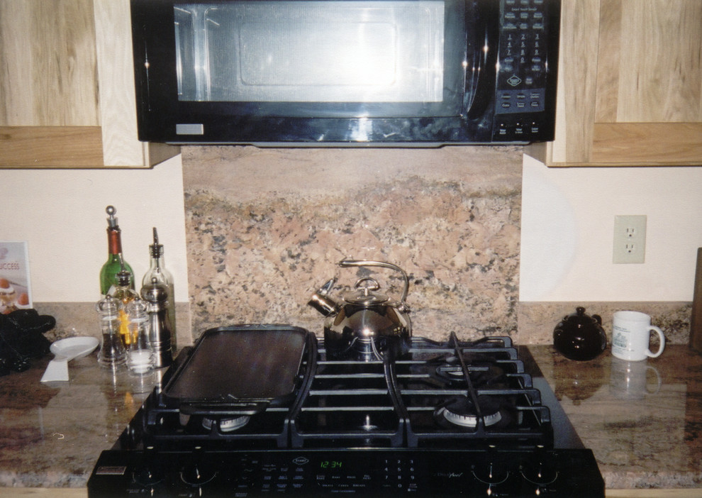 Example of a small transitional galley ceramic tile and brown floor kitchen design with an undermount sink, recessed-panel cabinets, light wood cabinets, marble countertops, brown backsplash, marble backsplash, black appliances, no island and brown countertops