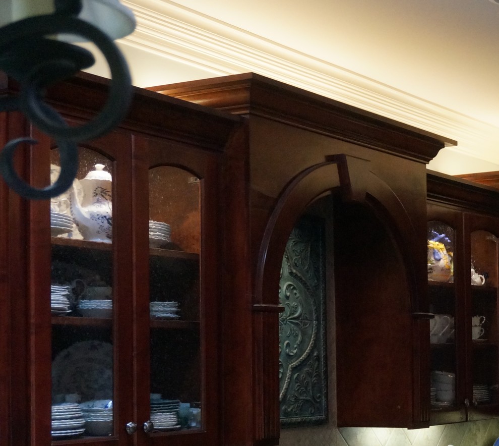 Large transitional u-shaped eat-in kitchen photo with glass-front cabinets, granite countertops and an island