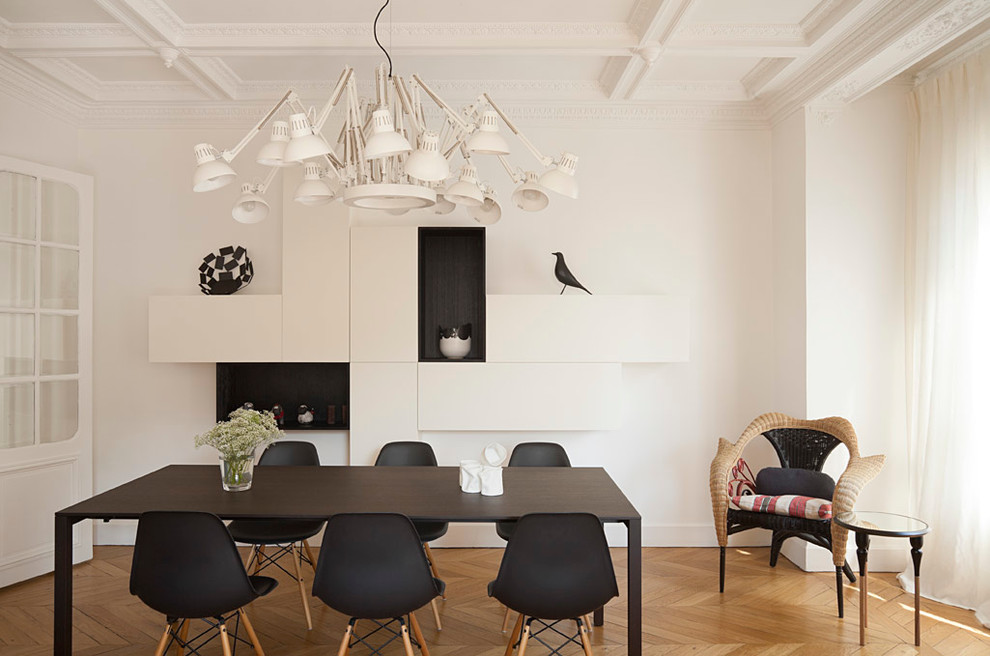 Inspiration for a contemporary separate dining room in Paris with white walls and light hardwood floors.