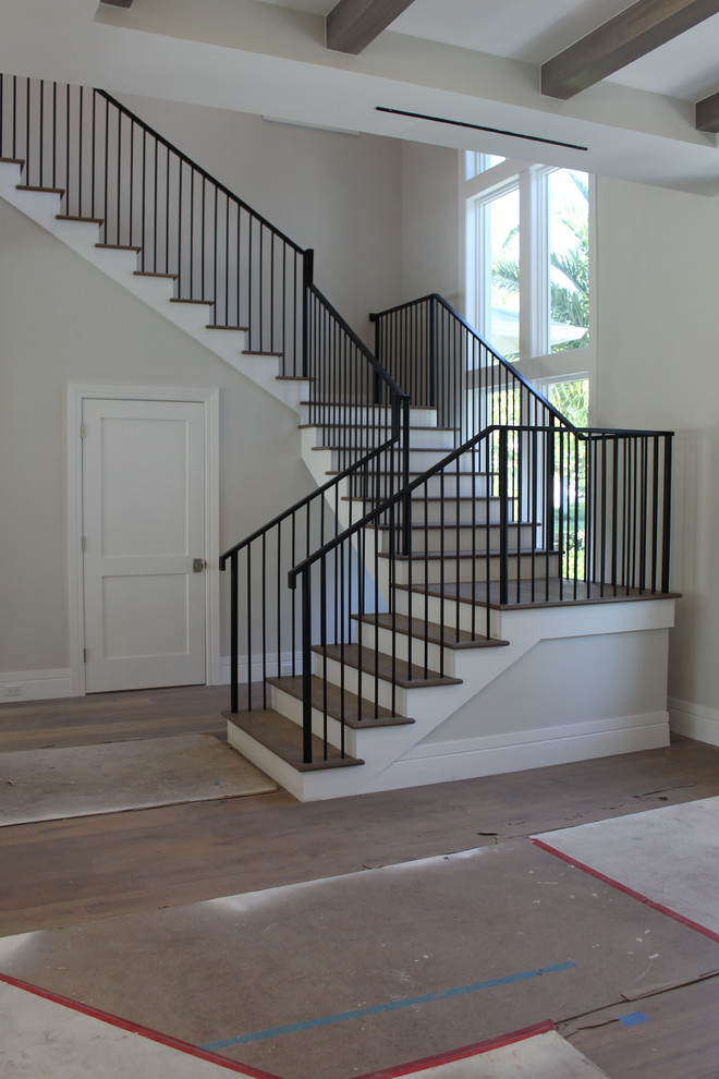 Design ideas for a mid-sized transitional wood l-shaped staircase in Other with wood risers and metal railing.