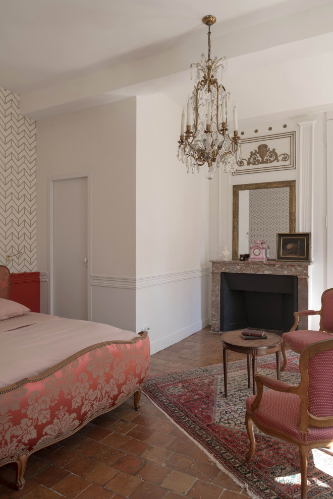 Modelo de habitación de invitados clásica renovada grande con paredes rojas, suelo de baldosas de terracota, todas las chimeneas y papel pintado