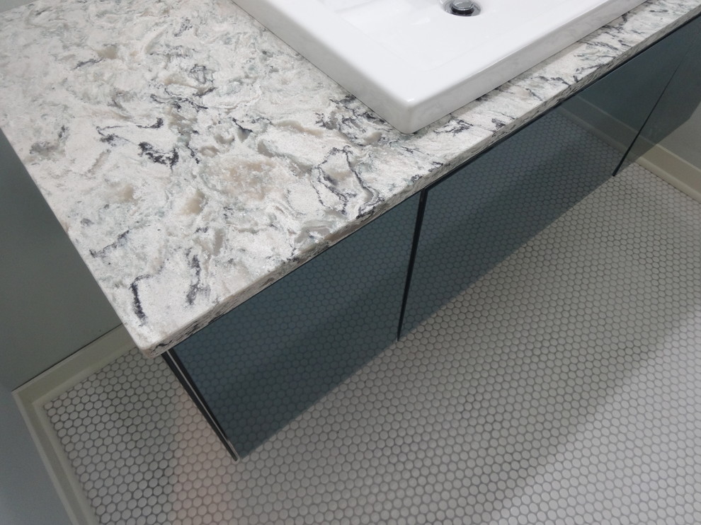 Inspiration for a mid-sized transitional kids' white tile and mosaic tile mosaic tile floor alcove bathtub remodel in Milwaukee with glass-front cabinets, gray cabinets, a two-piece toilet, green walls, a drop-in sink and quartz countertops