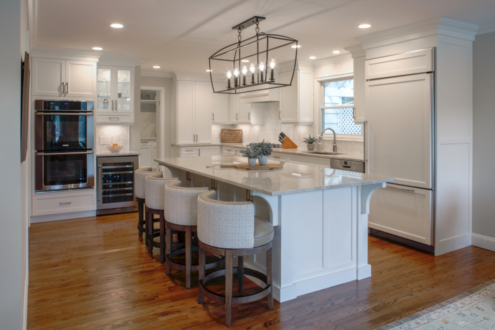 Example of a minimalist eat-in kitchen design in New York with flat-panel cabinets, white cabinets, quartzite countertops, an island and beige countertops