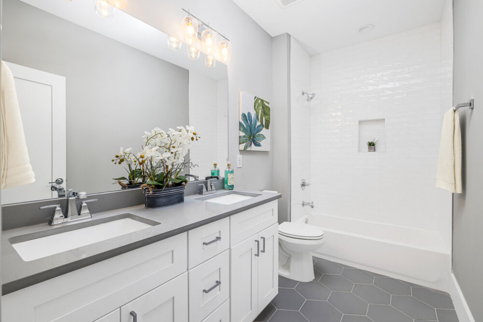 Photo of a large transitional kids bathroom in Atlanta with shaker cabinets, white cabinets, a freestanding tub, an alcove shower, a two-piece toilet, gray tile, ceramic tile, grey walls, ceramic floors, an undermount sink, quartzite benchtops, grey floor, white benchtops, a niche, a single vanity and a freestanding vanity.