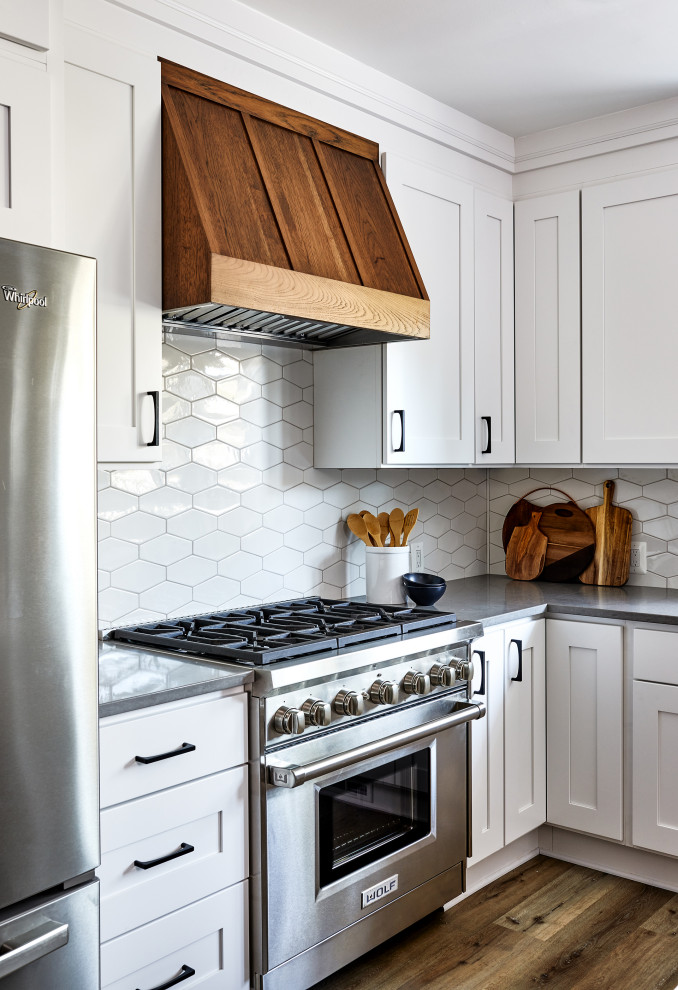 Foto de cocina comedor tradicional renovada de tamaño medio con electrodomésticos de acero inoxidable, suelo de madera en tonos medios y una isla