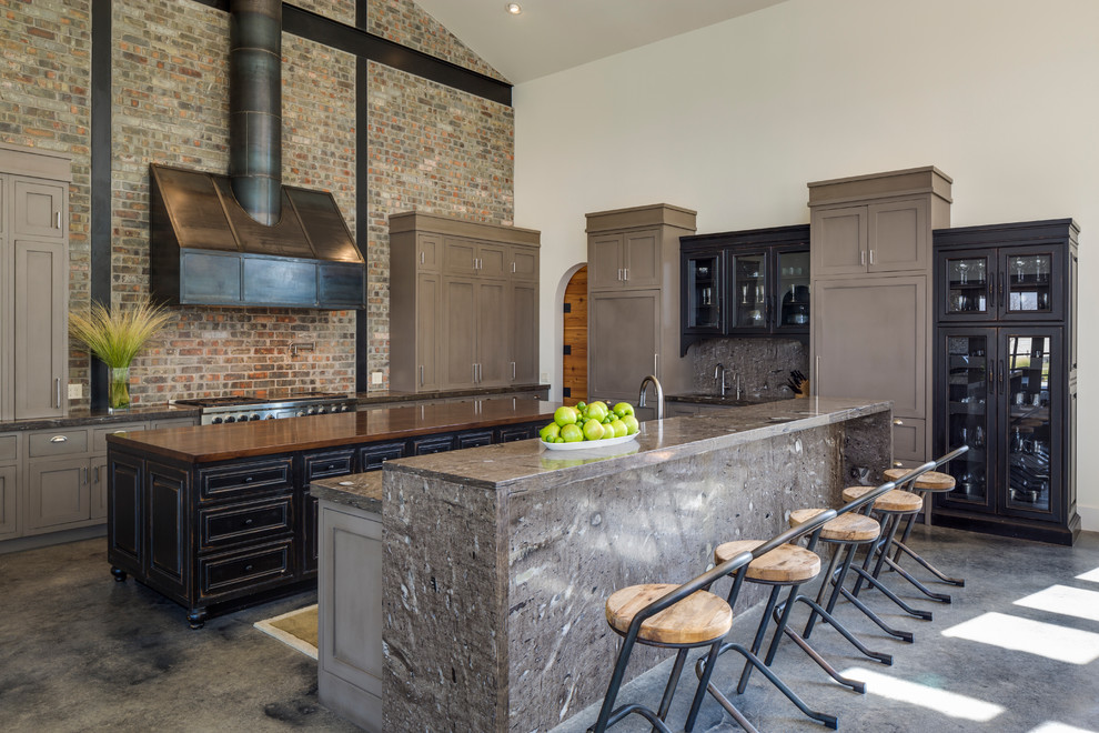 Photo of an expansive transitional kitchen in Austin with panelled appliances, concrete floors, glass-front cabinets, black cabinets, wood benchtops and multiple islands.