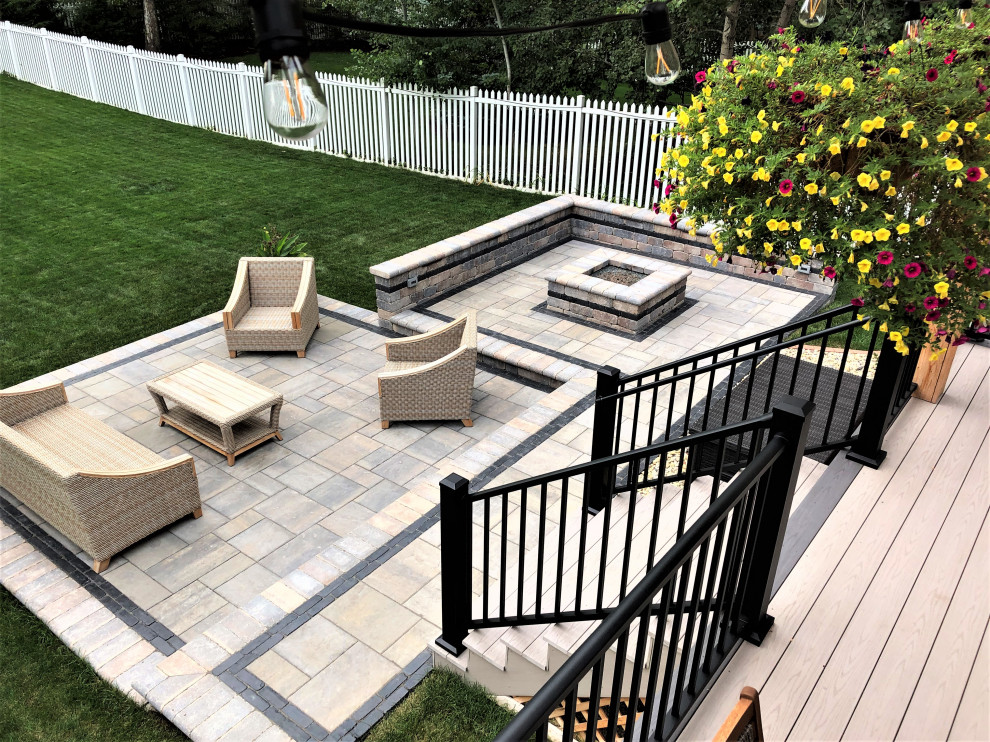 This is an example of a transitional backyard patio in Chicago with brick pavers and a pergola.