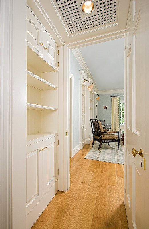 This is an example of a large traditional storage and wardrobe in New York with raised-panel cabinets, white cabinets and medium hardwood floors.