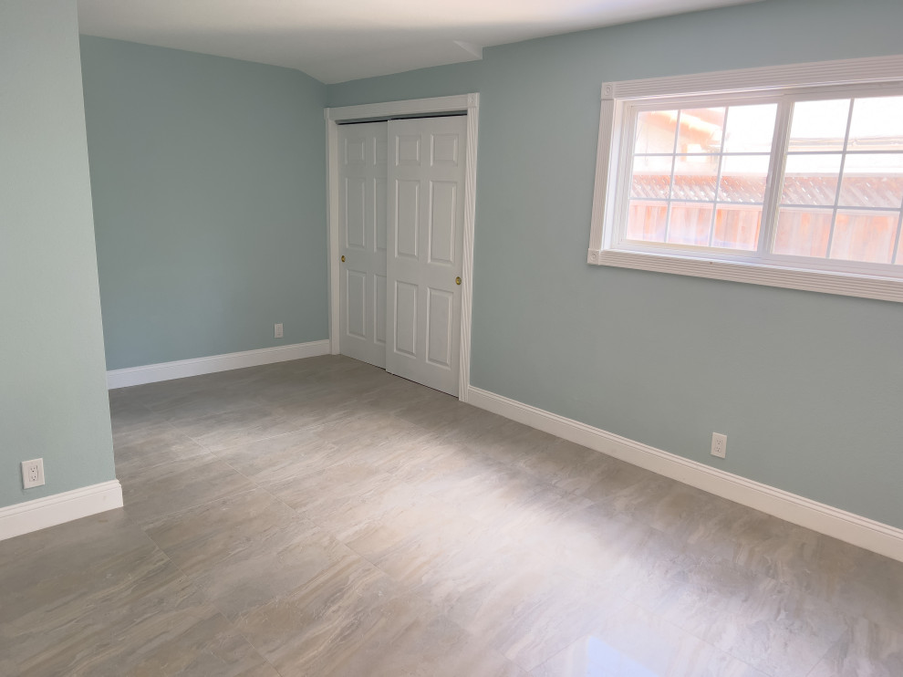 Aménagement d'une chambre parentale moderne de taille moyenne avec un mur bleu, un sol en carrelage de céramique et un sol gris.