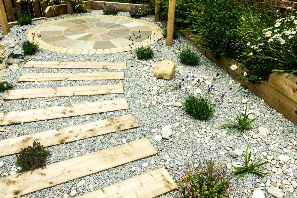 This is an example of a mid-sized contemporary backyard shaded formal garden for summer in Other with a container garden and natural stone pavers.