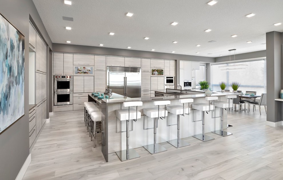 Inspiration for a large contemporary u-shaped eat-in kitchen in Edmonton with an undermount sink, louvered cabinets, grey cabinets, quartz benchtops, stainless steel appliances, porcelain floors, multiple islands, grey floor and white benchtop.