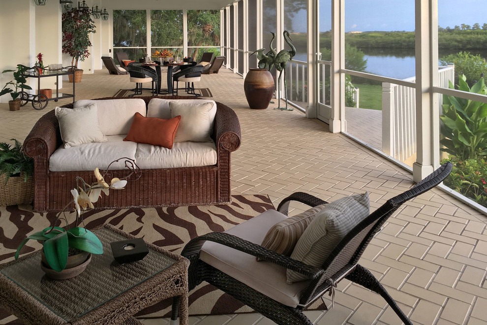 Design ideas for a large transitional backyard patio in Tampa with tile and a roof extension.