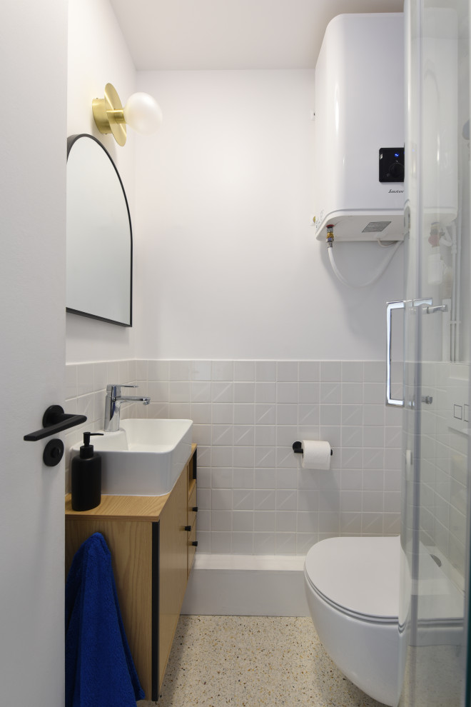 Foto di una piccola stanza da bagno minimal con WC sospeso, pareti bianche, pavimento alla veneziana, lavabo a consolle e pavimento bianco