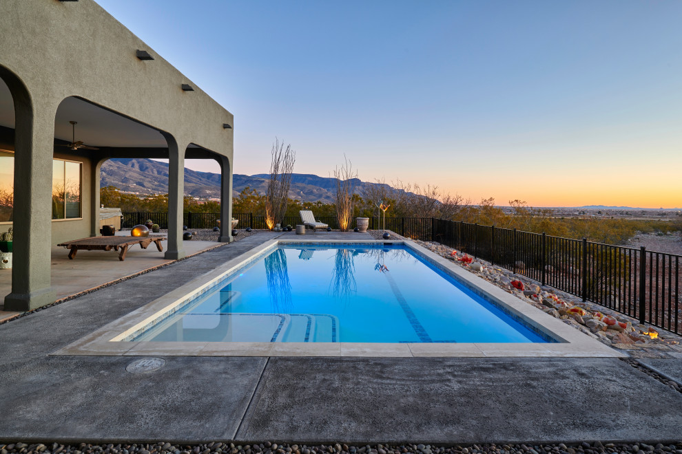 Photo of a mid-sized contemporary backyard rectangular pool in Other with concrete slab.