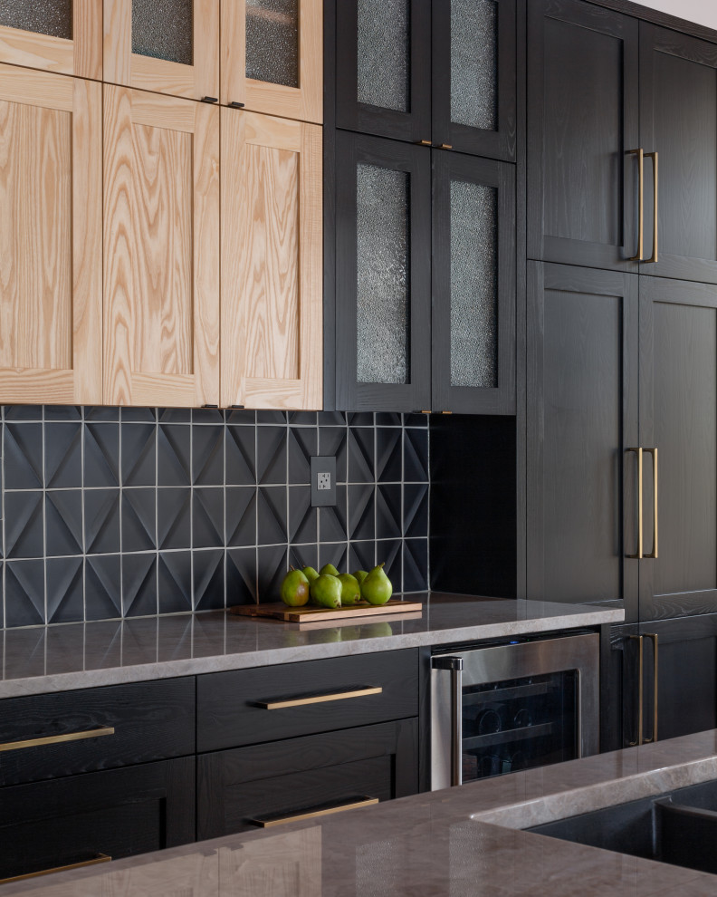 Large transitional l-shaped light wood floor, brown floor and exposed beam eat-in kitchen photo with a double-bowl sink, shaker cabinets, black cabinets, quartzite countertops, black backsplash, ceramic backsplash, stainless steel appliances, an island and gray countertops