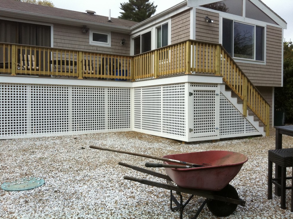 Example of a mid-sized backyard deck design in Boston with no cover