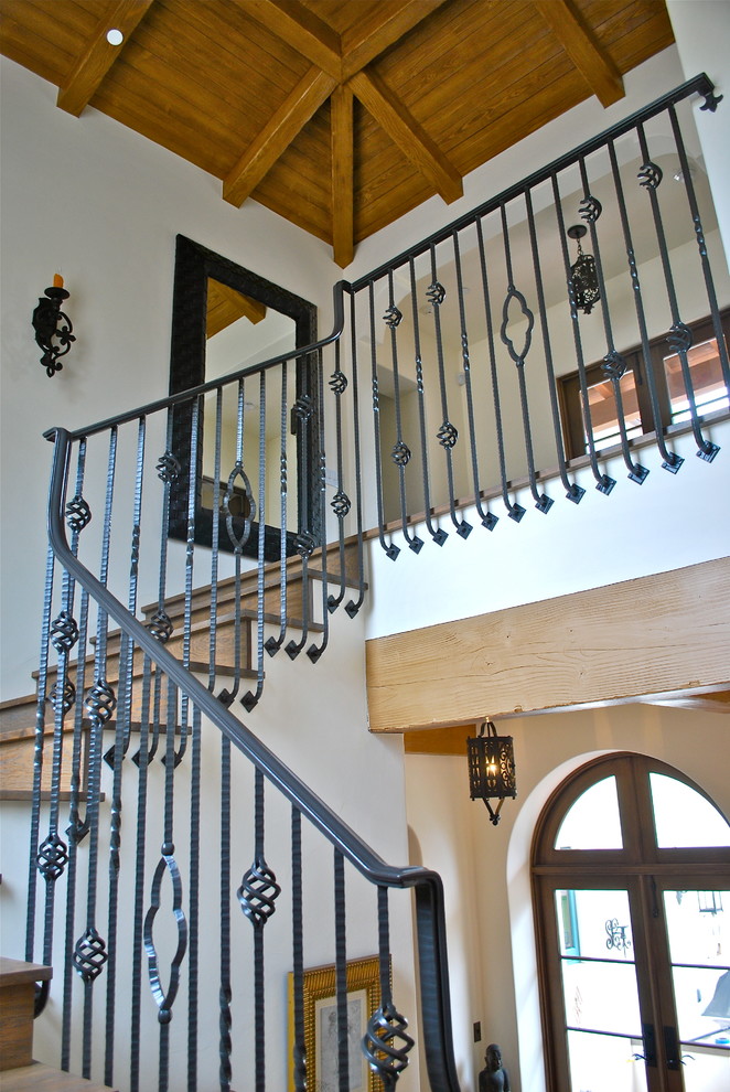 Mediterranean wood u-shaped staircase in Santa Barbara with wood risers.
