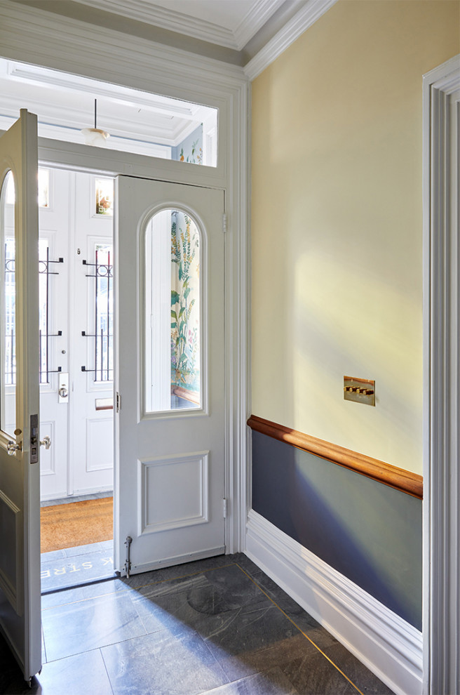 Small traditional vestibule in New York with yellow walls, a double front door and a white front door.