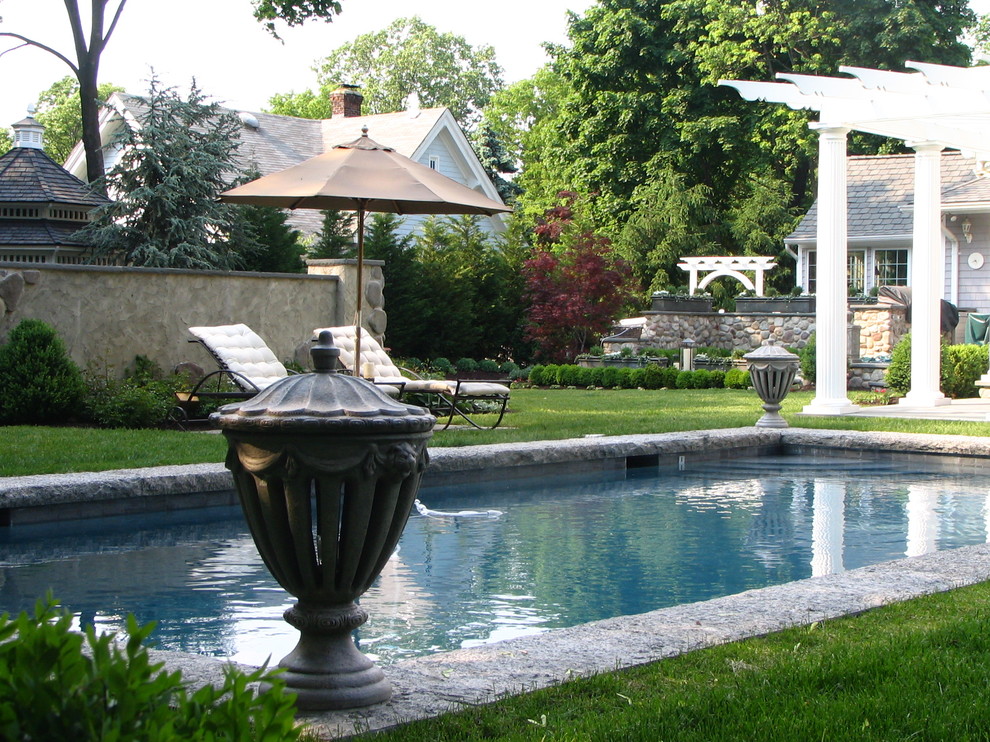 This is an example of a small traditional backyard rectangular lap pool in New York with natural stone pavers.