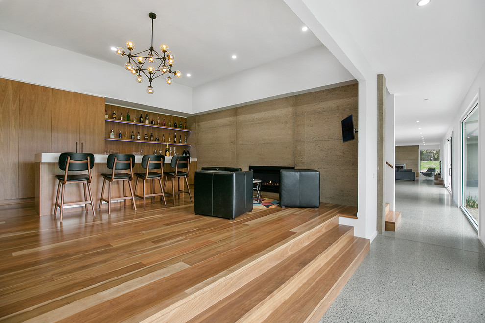 Inspiration for an expansive contemporary galley seated home bar in Geelong with an undermount sink, flat-panel cabinets, medium wood cabinets, quartz benchtops, timber splashback and medium hardwood floors.