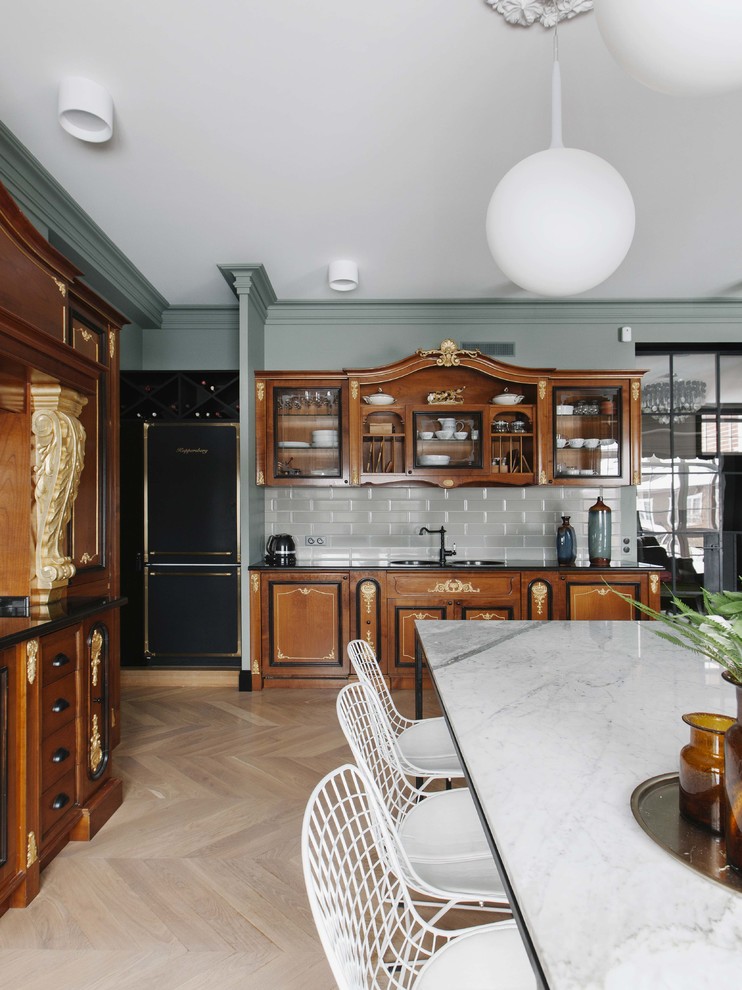 Inspiration for a transitional eat-in kitchen in Moscow with a double-bowl sink, medium wood cabinets, grey splashback, light hardwood floors, no island, beige floor and black benchtop.