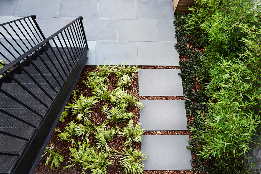 Inspiration for a small contemporary backyard partial sun garden in New York with natural stone pavers.