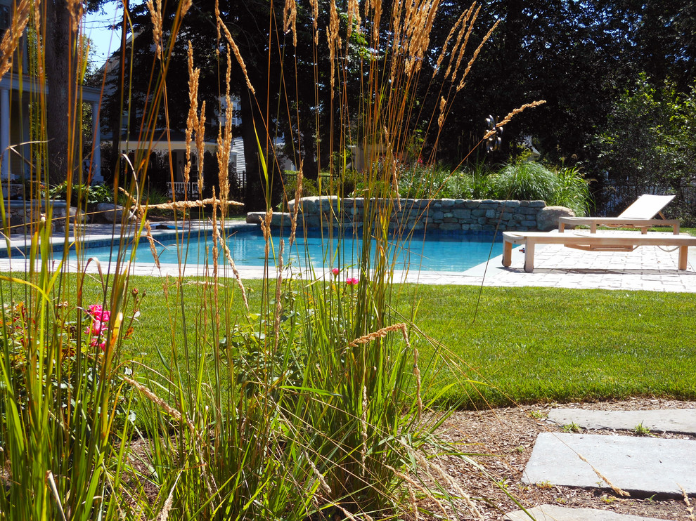 Large traditional side yard rectangular pool in Providence with a water feature and concrete pavers.