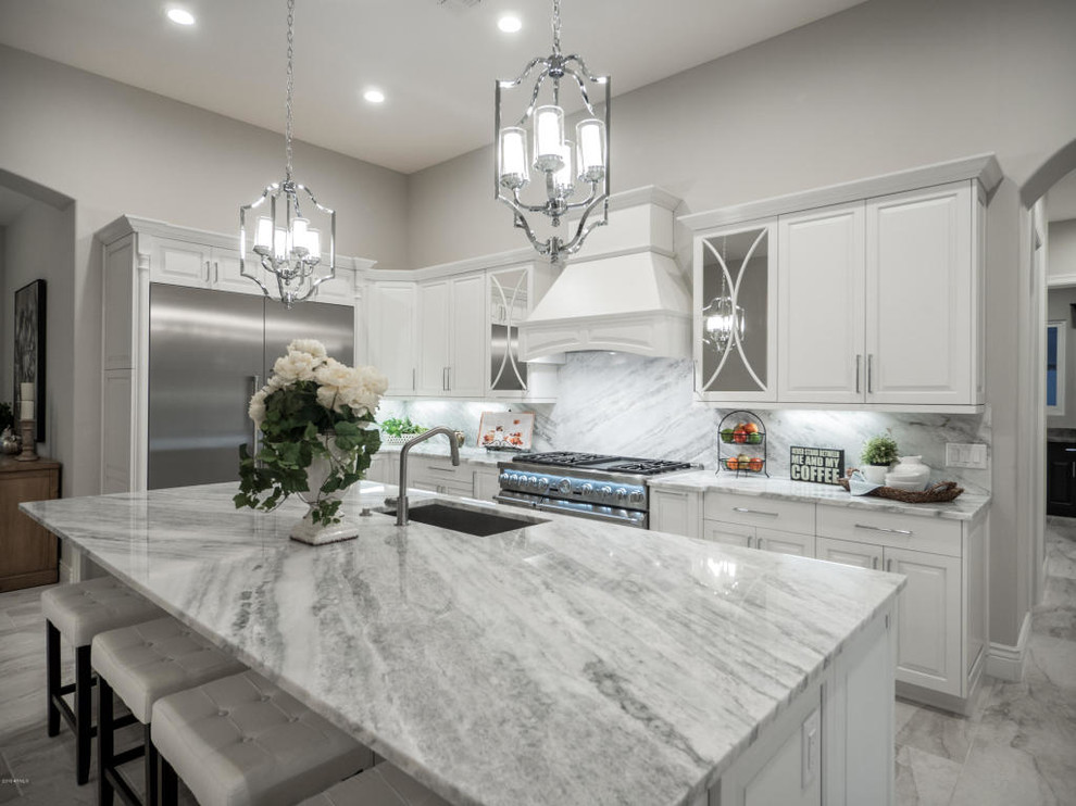 Example of a mid-sized transitional u-shaped marble floor and gray floor eat-in kitchen design in Phoenix with an undermount sink, raised-panel cabinets, white cabinets, marble countertops, white backsplash, marble backsplash, stainless steel appliances, an island and gray countertops