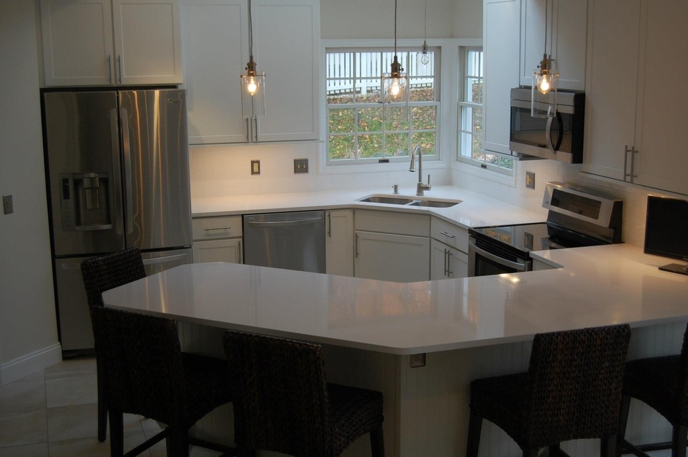 Example of a small transitional u-shaped ceramic tile and beige floor kitchen design in St Louis with a double-bowl sink, shaker cabinets, white cabinets, quartz countertops, stainless steel appliances, a peninsula and white countertops