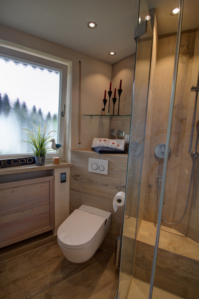 This is an example of a small traditional 3/4 bathroom in Munich with flat-panel cabinets, beige cabinets, a curbless shower, a two-piece toilet, beige tile, wood-look tile, beige walls, wood-look tile, an integrated sink, glass benchtops, brown floor, a hinged shower door, white benchtops, a shower seat, a single vanity, a floating vanity, recessed and wallpaper.