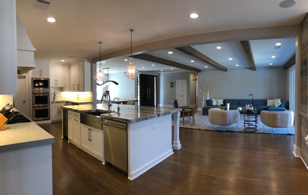 Open concept kitchen - large transitional l-shaped medium tone wood floor and brown floor open concept kitchen idea in Dallas with an undermount sink, shaker cabinets, white cabinets, quartz countertops, gray backsplash, ceramic backsplash, stainless steel appliances and an island