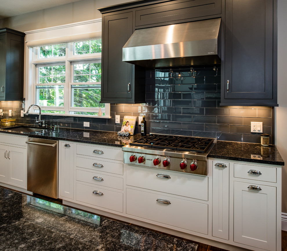 Inspiration for a large transitional single-wall medium tone wood floor open concept kitchen remodel with an undermount sink, shaker cabinets, gray cabinets, granite countertops, gray backsplash, ceramic backsplash, stainless steel appliances and an island