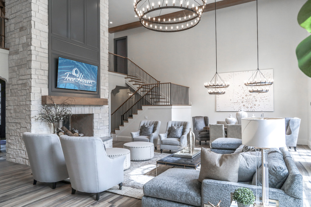 Inspiration for a large mediterranean open concept family room in Salt Lake City with beige walls, a two-sided fireplace, a stone fireplace surround, a wall-mounted tv, brown floor and ceramic floors.