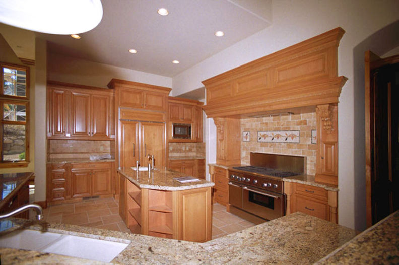 Photo of a large traditional u-shaped eat-in kitchen in Atlanta with an undermount sink, raised-panel cabinets, medium wood cabinets, granite benchtops, beige splashback, ceramic splashback, stainless steel appliances, ceramic floors and with island.