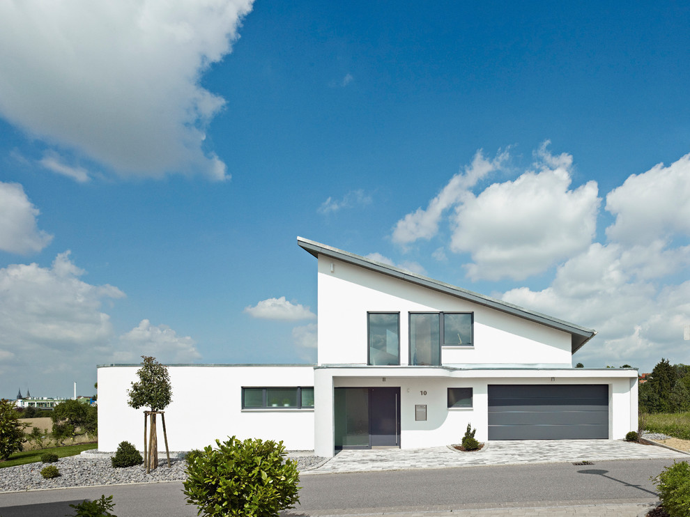 Inspiration for a large modern two-storey stucco white exterior in Stuttgart with a flat roof.