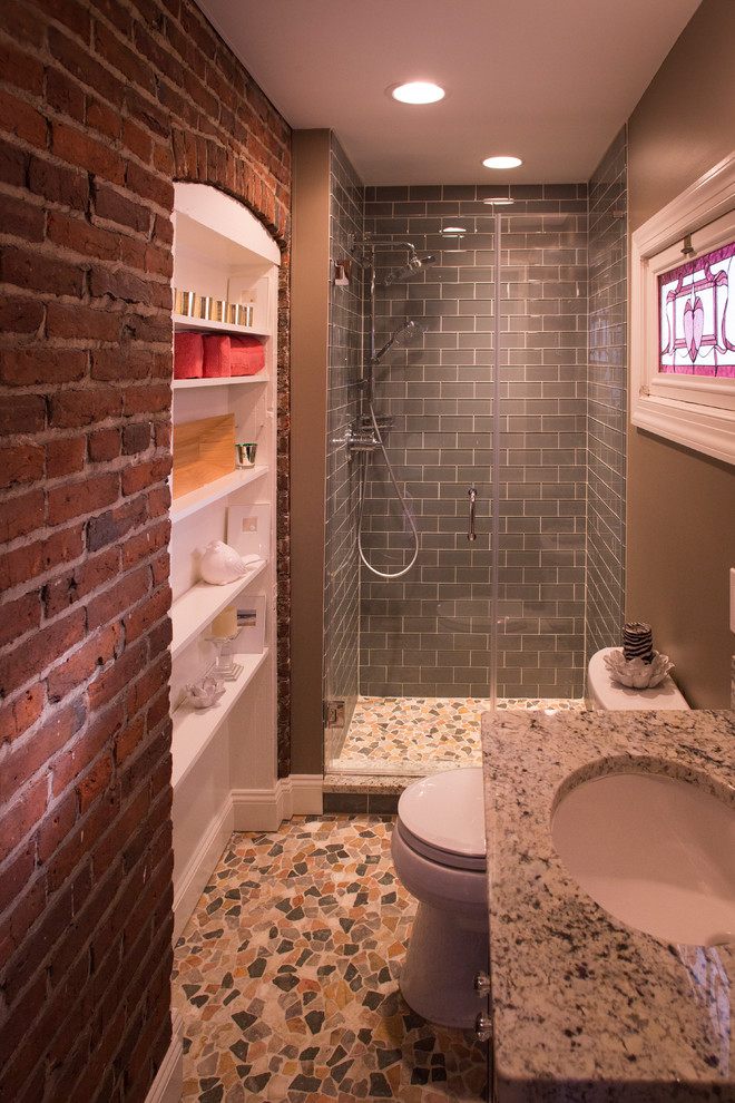 Design ideas for a mid-sized eclectic bathroom in New York with raised-panel cabinets, dark wood cabinets, gray tile, subway tile, beige walls, mosaic tile floors, an undermount sink and granite benchtops.