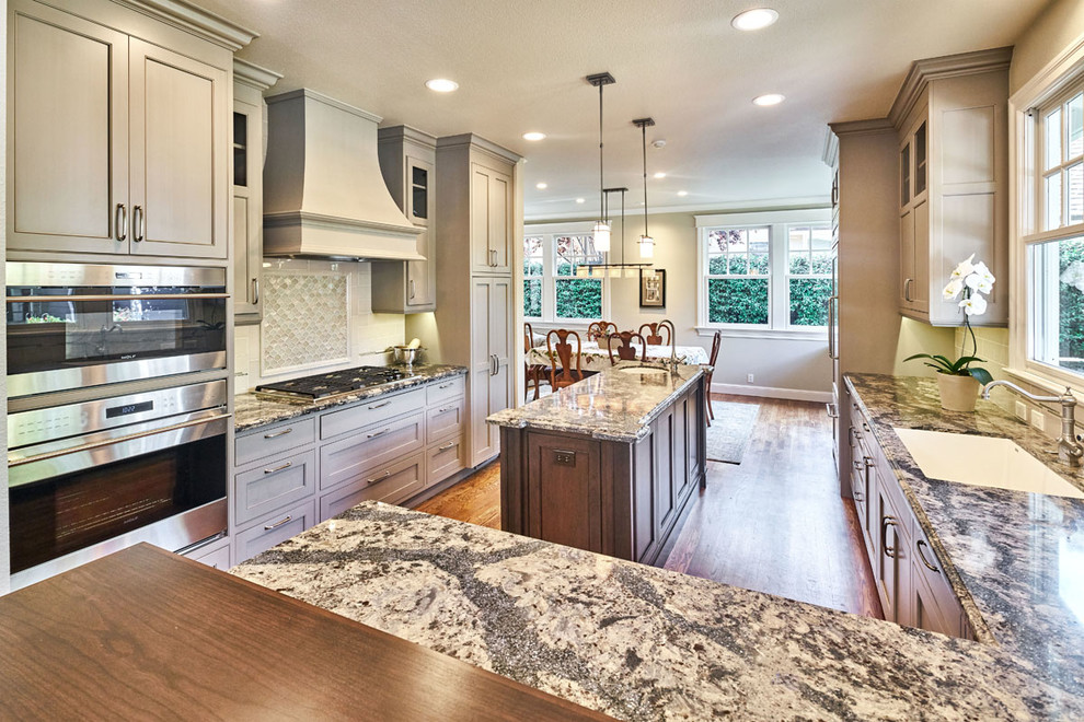 Eat-in kitchen - mid-sized transitional l-shaped medium tone wood floor eat-in kitchen idea in San Francisco with an undermount sink, beaded inset cabinets, gray cabinets, quartz countertops, gray backsplash, ceramic backsplash, paneled appliances and an island