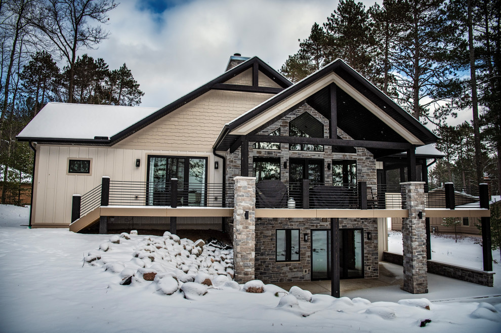 Large mountain style beige one-story wood and board and batten gable roof photo with a shingle roof and a black roof