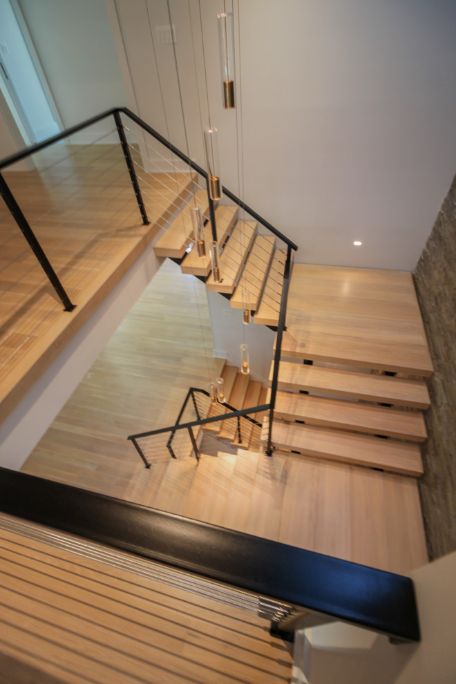 Large eclectic wood floating metal railing staircase in DC Metro with brick walls.