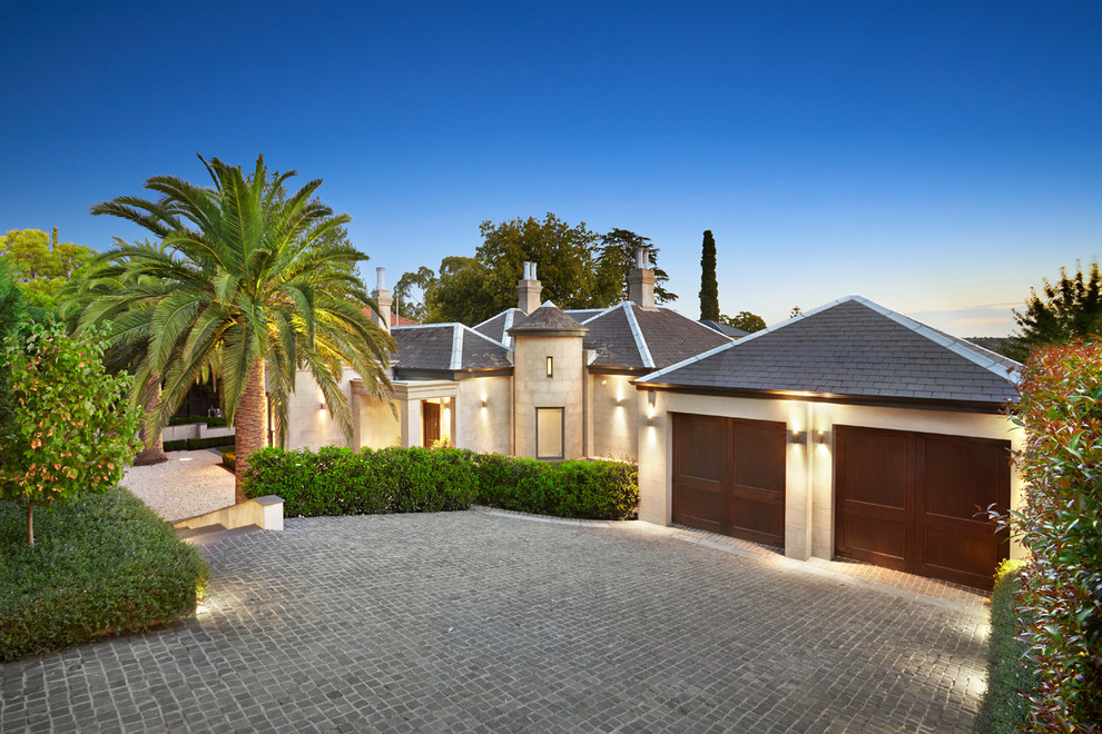 Inspiration for a large transitional beige house exterior in Melbourne with a hip roof and a tile roof.