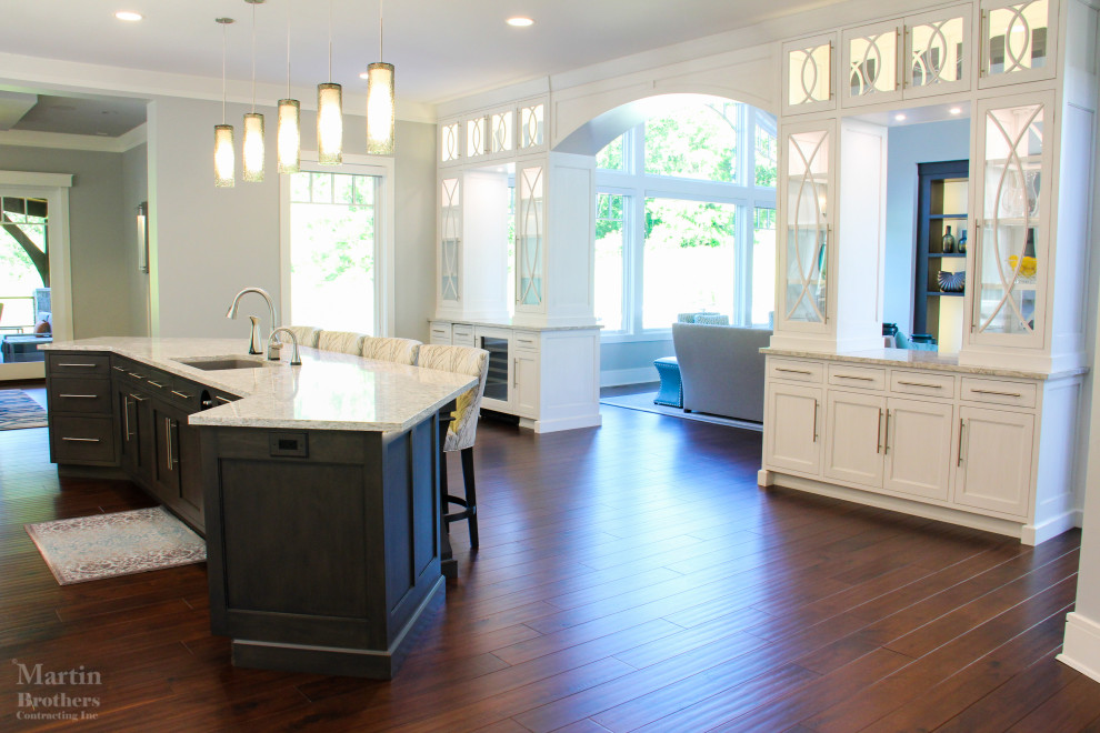 Kitchen pantry - huge transitional l-shaped dark wood floor kitchen pantry idea with an undermount sink, shaker cabinets, white cabinets, quartzite countertops, gray backsplash, ceramic backsplash, stainless steel appliances and two islands