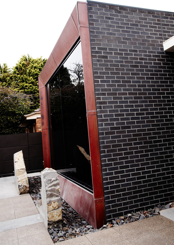 Inspiration for a large contemporary three-storey brick house exterior in Melbourne with a flat roof.