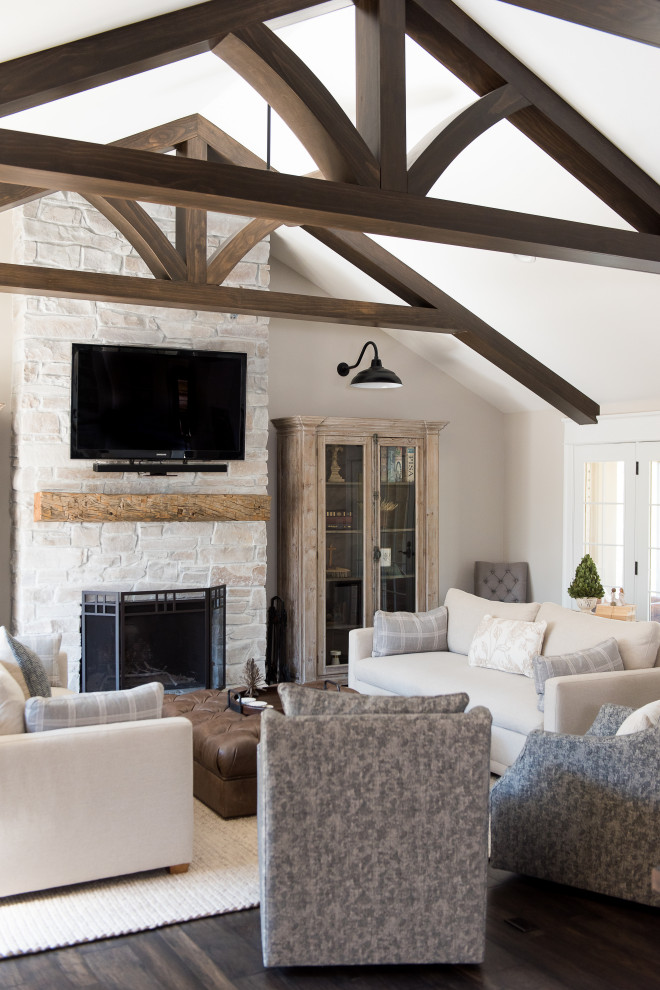 Design ideas for a large transitional open concept living room in Indianapolis with white walls, dark hardwood floors, a standard fireplace, a wall-mounted tv, a stone fireplace surround and brown floor.