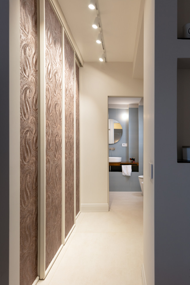 Ispirazione per un piccolo ingresso o corridoio design con pareti beige, pavimento in gres porcellanato, pavimento beige e carta da parati