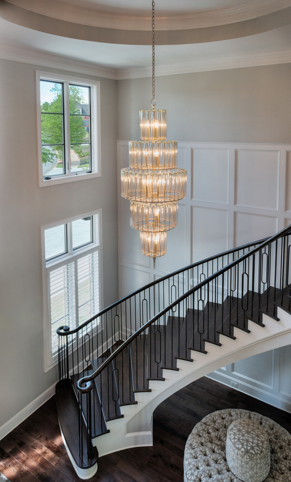 Inspiration for a large medium tone wood floor staircase remodel with white walls and a black front door