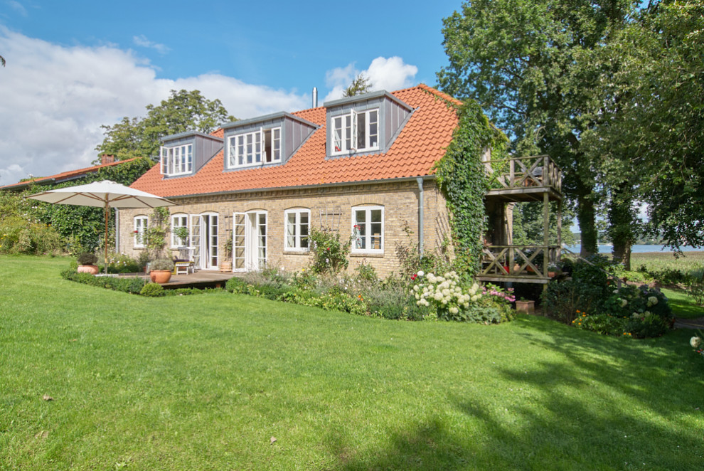 Diseño de fachada de casa roja clásica de una planta con revestimiento de ladrillo, tejado a la holandesa y tejado de teja de barro
