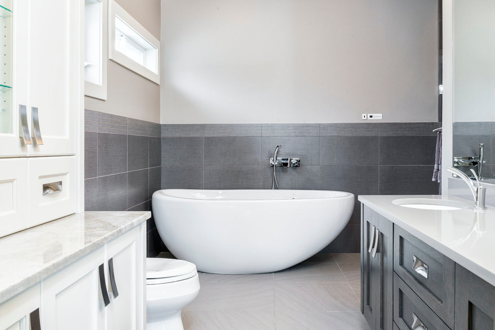 Inspiration for a large contemporary master bathroom in Vancouver with an undermount sink, grey cabinets, a freestanding tub, a corner shower, a two-piece toilet, gray tile, grey walls and ceramic floors.