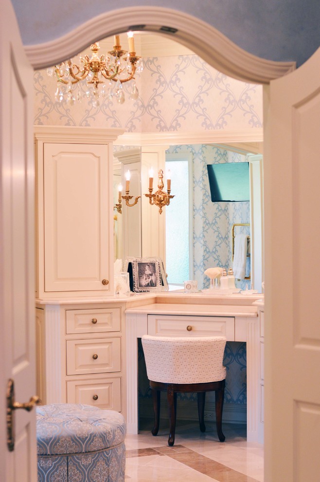 Photo of a large traditional bathroom in New Orleans with an undermount sink, raised-panel cabinets, white cabinets, marble benchtops, blue walls and marble floors.