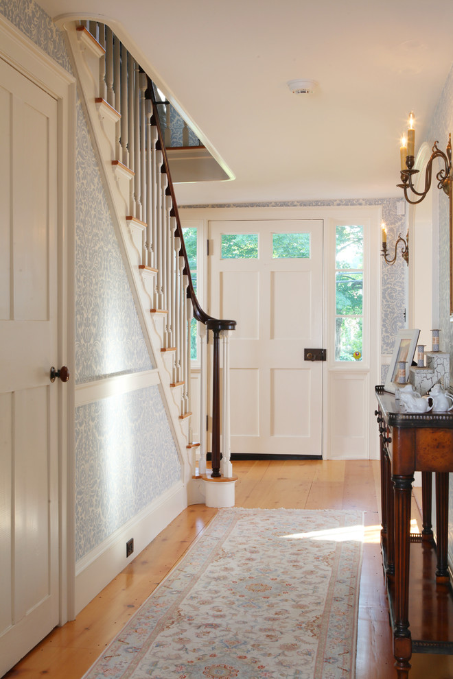 This is an example of a mid-sized country foyer in Boston with medium hardwood floors, a single front door, a white front door and multi-coloured walls.